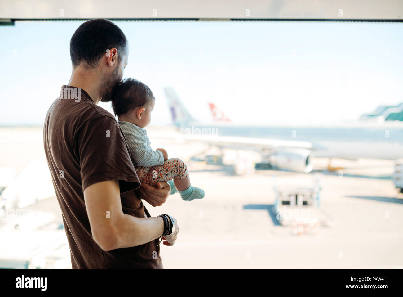 Homme tenant une petite fille à l'aéroport, à la recherche d'avions à la Banque D'Images