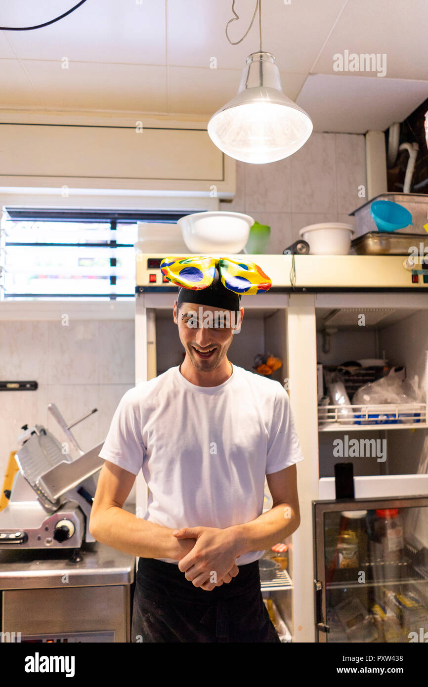 Portrait de drôle de clown pizza baker portant nœud papillon sur la tête Banque D'Images