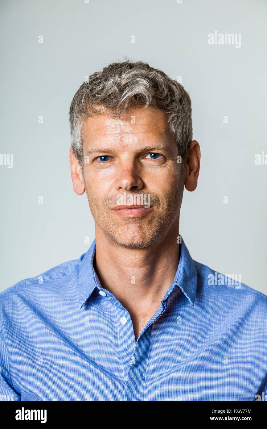 Portrait d'homme mûr avec des cheveux gris wearing blue shirt Banque D'Images