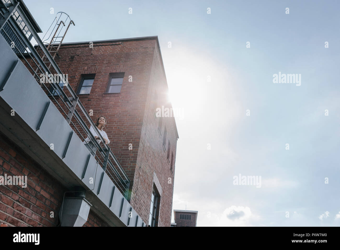 Businesswoman standing sur terrasse de bâtiments industriels Banque D'Images
