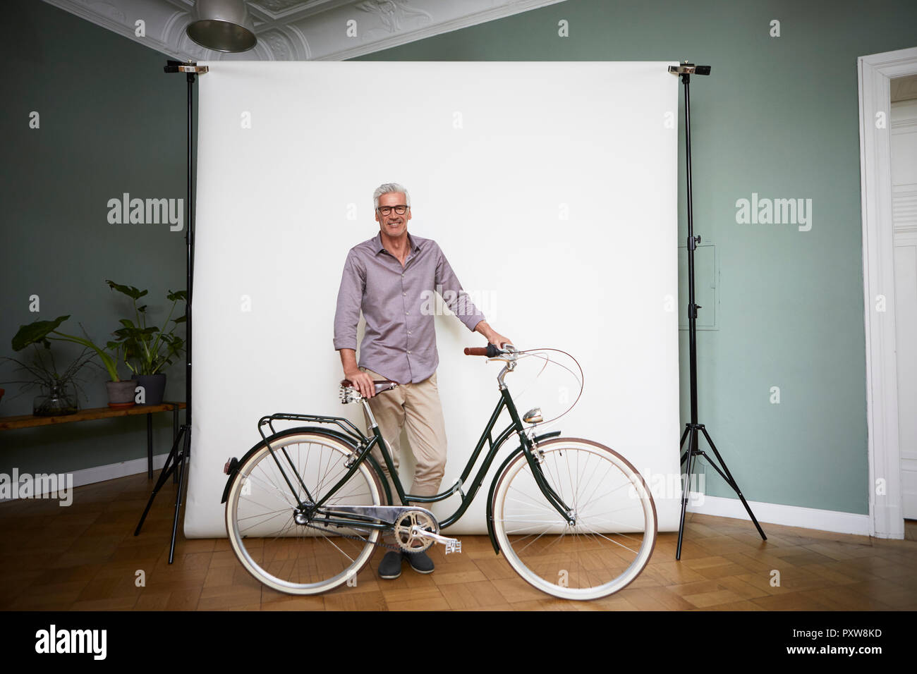 Le portrait de l'homme mûr qui posent avec vélo à écran de projection Banque D'Images