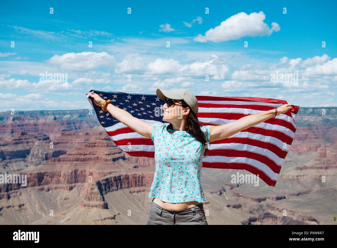 USA, Arizona, femme souriante avec le drapeau américain à Grand Canyon National Park Banque D'Images