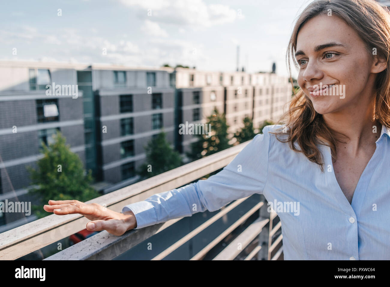 Businesswoman standing sur terrasse de bâtiments industriels Banque D'Images