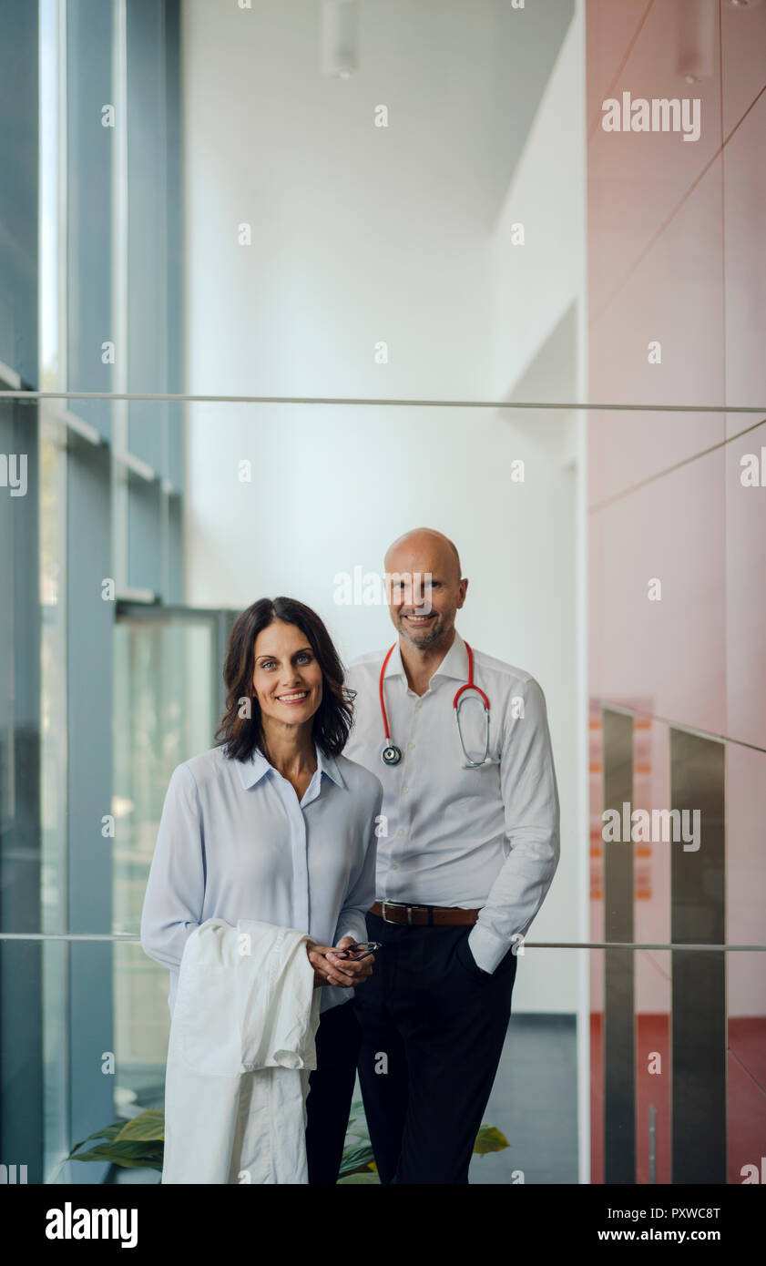 Friendly doctors standing in hospital, smiling Banque D'Images