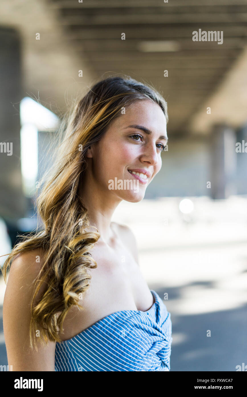 Portrait of smiling long-haired woman au passage sous Banque D'Images
