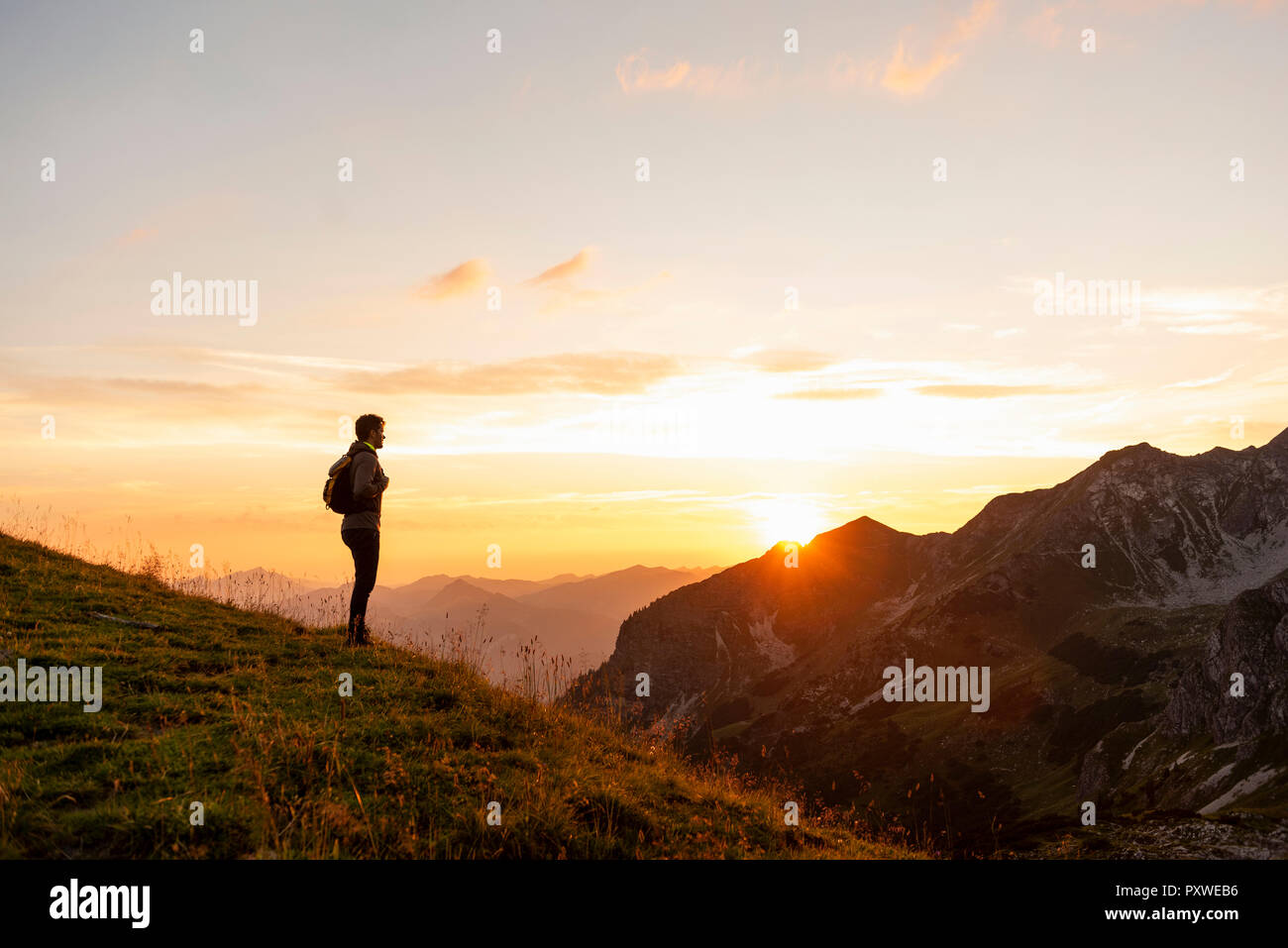 Allemagne, Bavière, Oberstdorf, l'homme l'occasion d'une randonnée dans les montagnes à la recherche de voir au coucher du soleil Banque D'Images