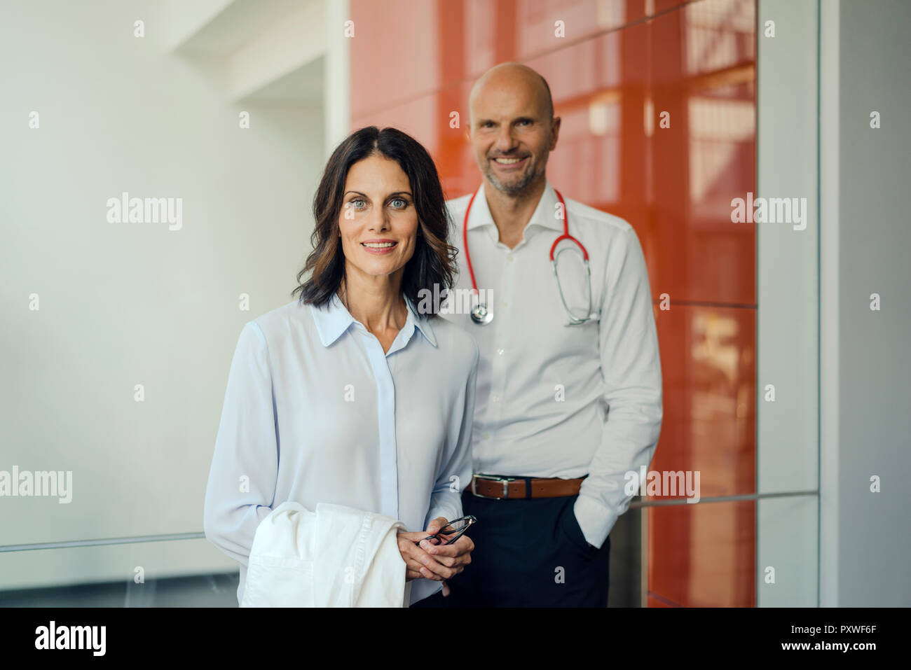 Friendly doctors standing in hospital, smiling Banque D'Images