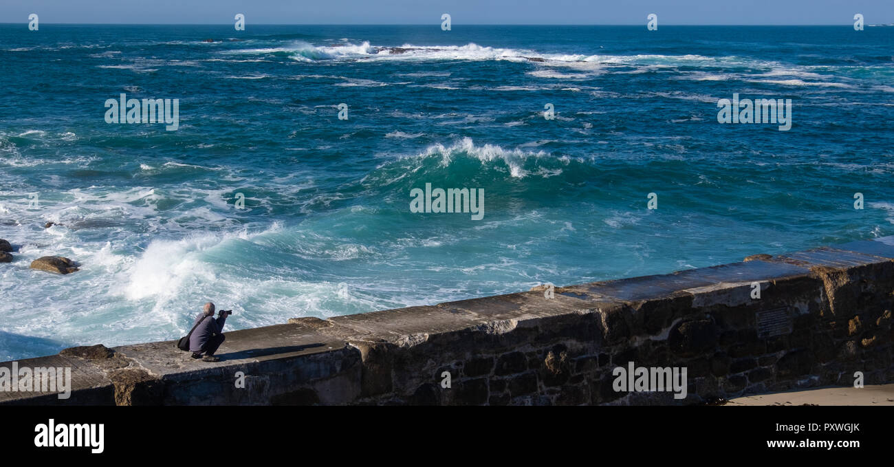 Les braves photographe le vent et les vagues massives d'obtenir une photo en étant sur le mur du port d'être violé par des vagues de la mer Banque D'Images