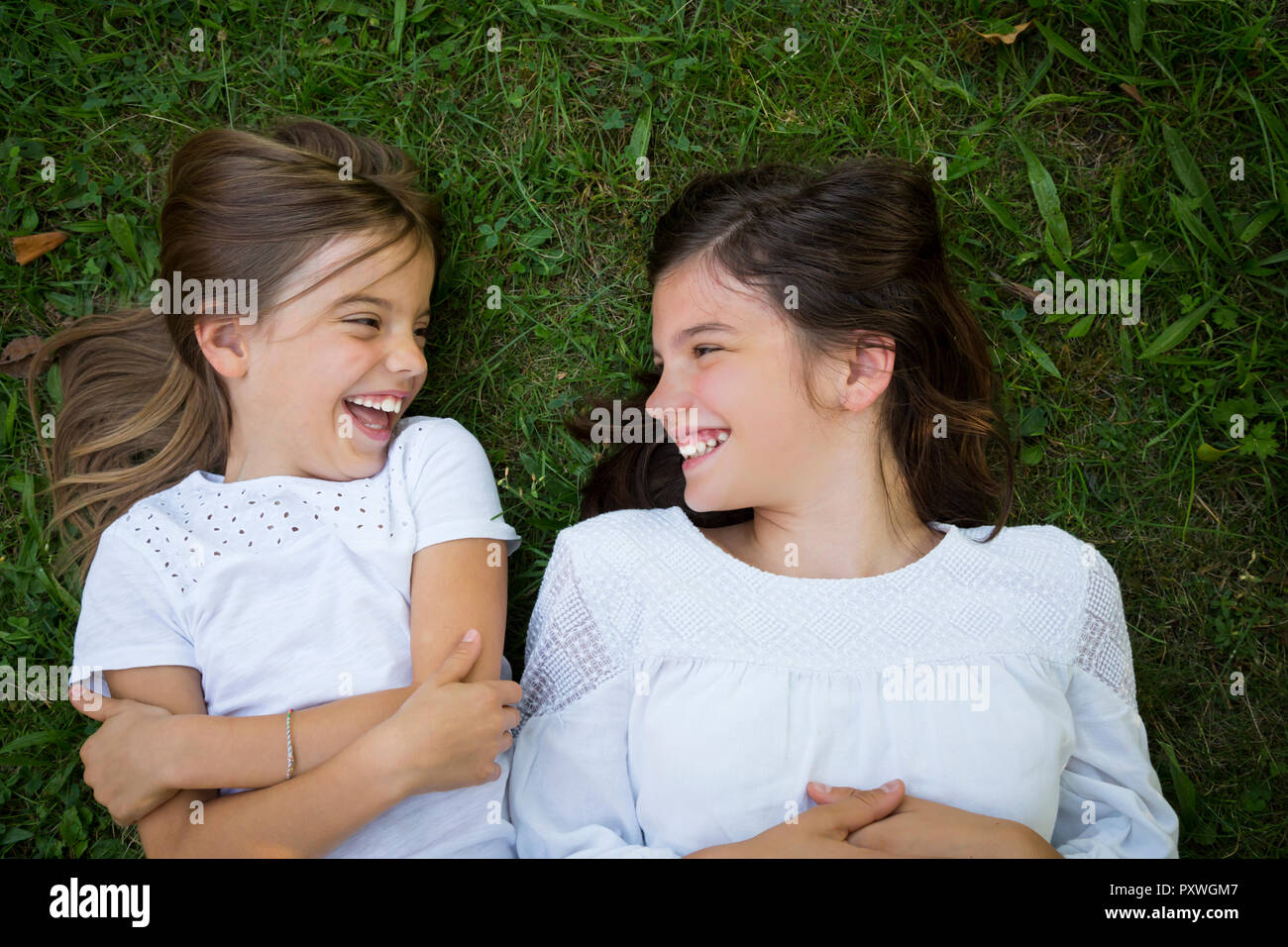 Deux sœurs couché ensemble sur une prairie s'amusant Banque D'Images