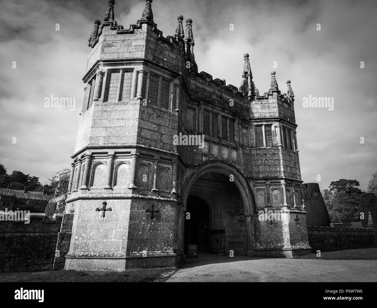 Noir et blanc, grand angle vers le haut face à l'image, de l'énorme tour double, de style gothique voûté en pierre, entrée de Lanhydrock House à Cornwall. Banque D'Images