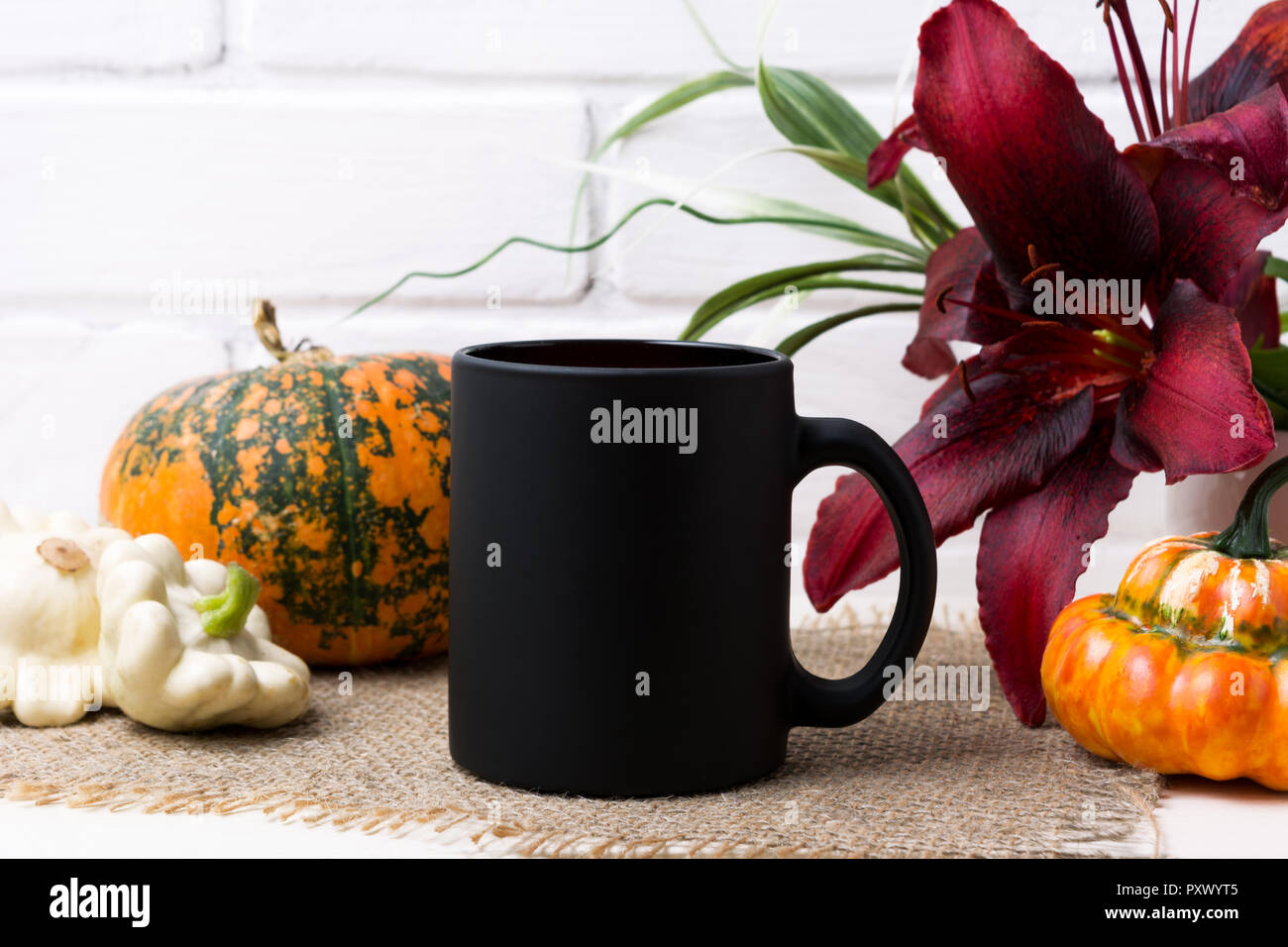 Tasse à café noir avec la maquette de l'automne de l'action orange citrouille et red lily. Mug vide maquette pour la promotion de marque. Banque D'Images