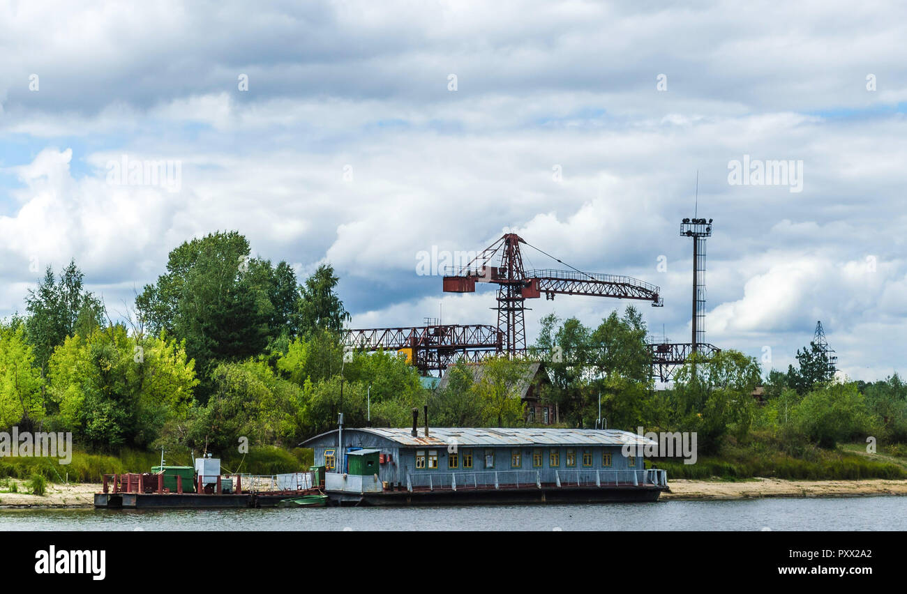 Un vieux bateau abandonné grand plaisir bateau en bois debout sur l'eau de la rivière Pripyat près de l'ancien port sur le contexte de la construction cr Banque D'Images