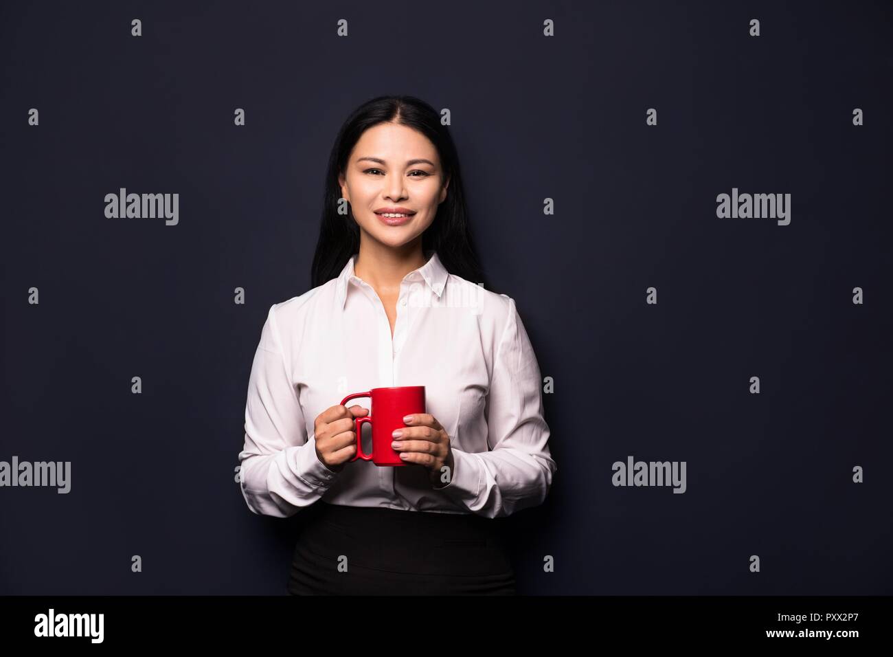 Businesswoman bénéficiant d'pause café holding red cup Banque D'Images