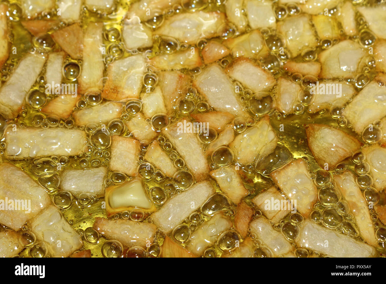 Une vue rapprochée d'un oignon sautée d'être frits dans l'huile d'olive vierge, avec des bulles d'ébullition Banque D'Images