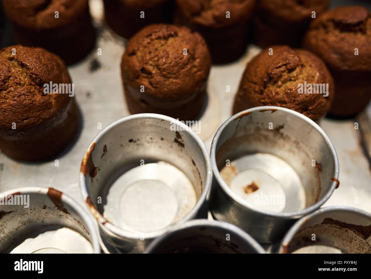 Des muffins fraîchement cuits assis avec boîtes sur un comptoir de boulangerie Banque D'Images