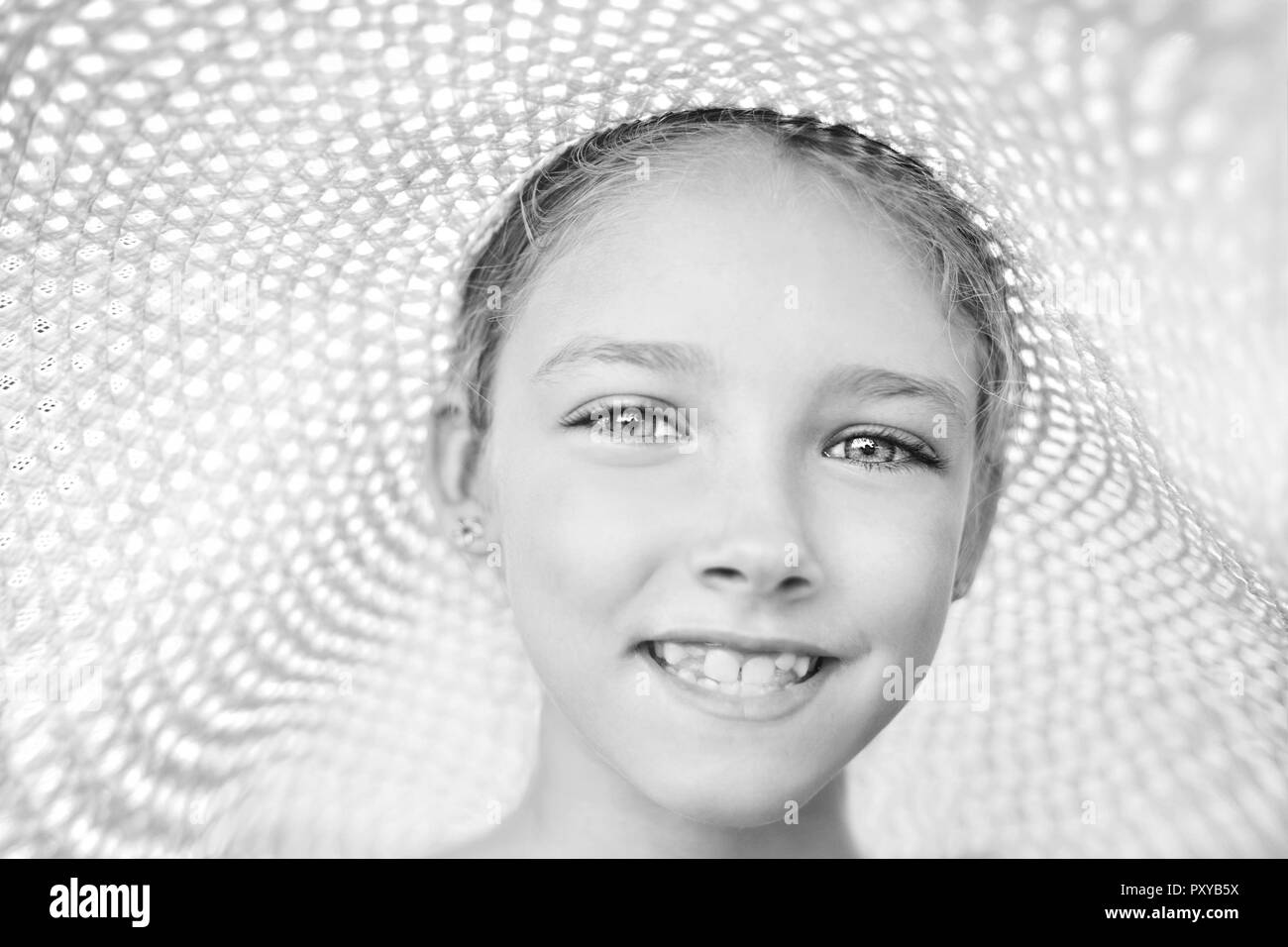 Portrait d'été d'une belle jeune fille dans un chapeau. La notion d'enfance. Photo en noir et blanc. Banque D'Images