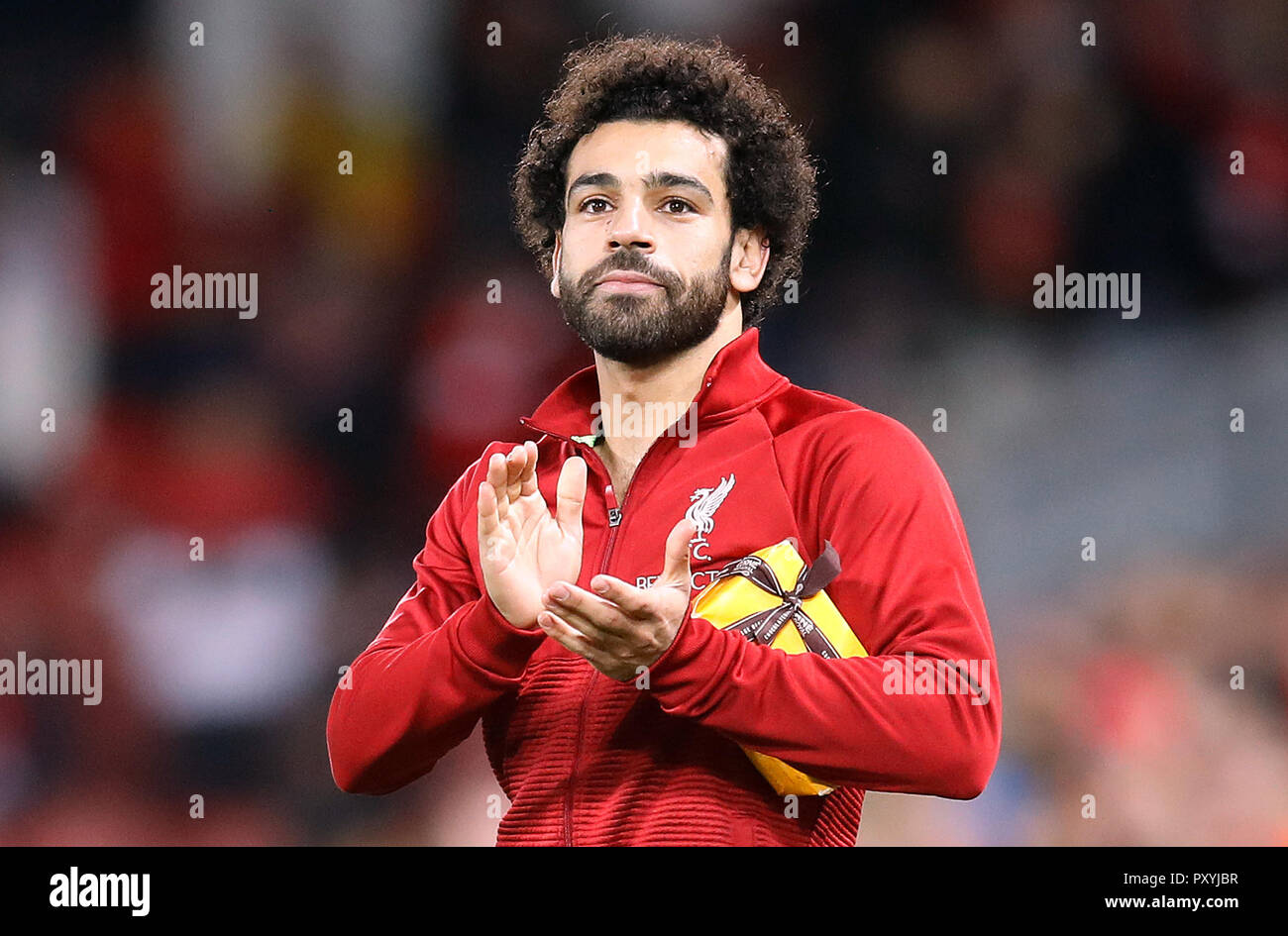 Le centre de Liverpool, Mohamed Salah applaudit les fans tenant un présent d'un membre de la foule après la Ligue des Champions, Groupe C match à Anfield, Liverpool. Banque D'Images