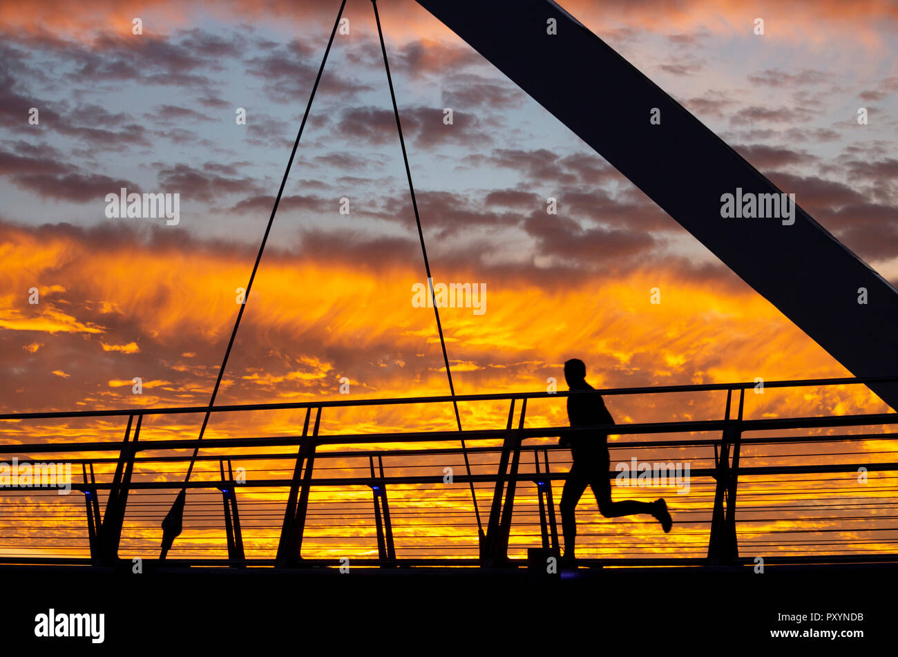 Stockton on Tees, Angleterre du Nord-Est, Royaume-Uni. 24 Oct, 2018. Météo : Les personnes qui traversent l'Infini pont sur la Rivière Tees à Stockton sont traités à un spectaculaire coucher de soleil sur le mercredi. Credit : ALAN DAWSON/Alamy Live News Banque D'Images