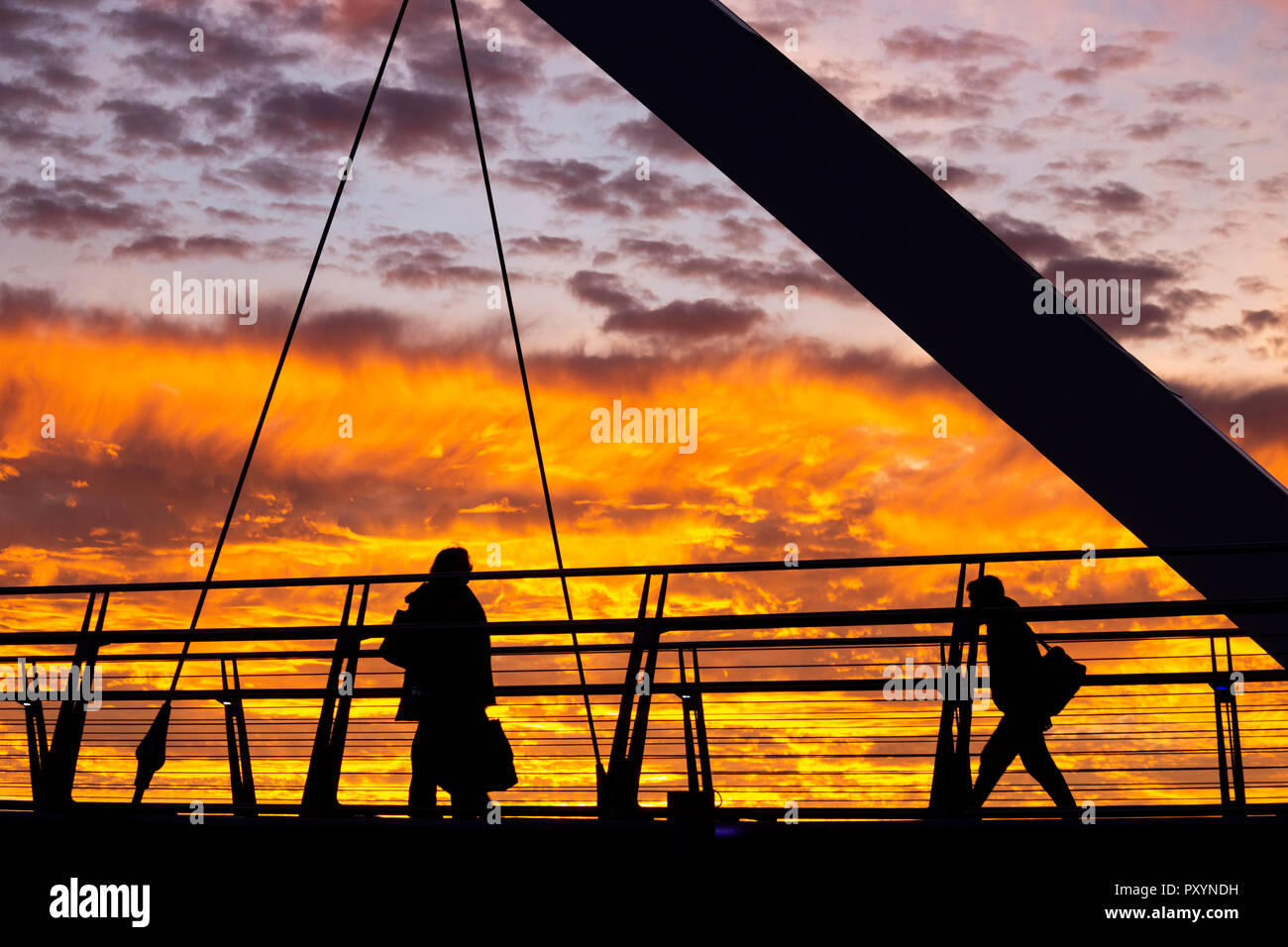 Stockton on Tees, Angleterre du Nord-Est, Royaume-Uni. 24 Oct, 2018. Météo : Les personnes qui traversent l'Infini pont sur la Rivière Tees à Stockton sont traités à un spectaculaire coucher de soleil sur le mercredi. Credit : ALAN DAWSON/Alamy Live News Banque D'Images