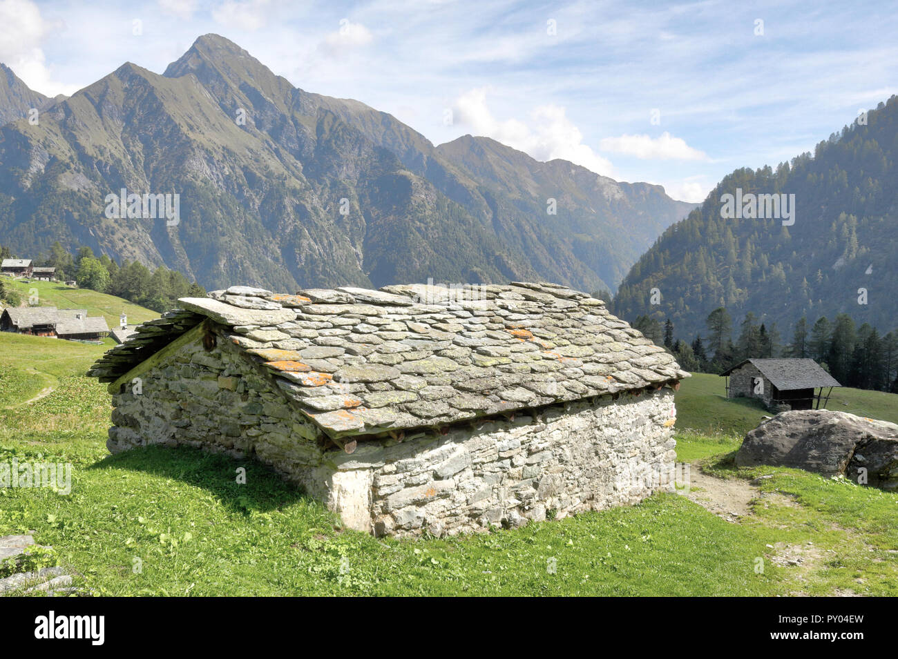 Une cabane en pierre dans la ville de Walser Follu, entre de hautes montagnes, forêts de pins et de verts pâturages, en été, dans le Val d'Otro vallée, Alpes, Italie Banque D'Images