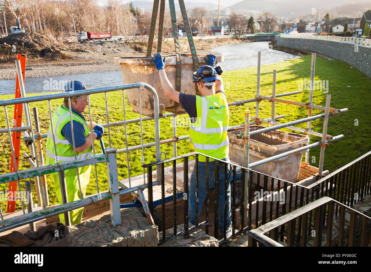 À la suite des inondations catastrophiques de 2009 dans la région de Cumbria, l'Agence de l'environnement sont prévues ÂỲÂẀÂỲÂ£6,1 millions de dollars sur un nouveau plan de défense contre les inondations de Keswick. Cette photo montre l'homme des travailleurs de la construction de la manipulation du ciment pour construire les nouvelles défenses. En dépit coûtant plus ÂỲÂẀÂỲÂ£6millions, ils ont été complètement dominés par les inondations de Storm Desmond, 6 ans plus tard. Banque D'Images