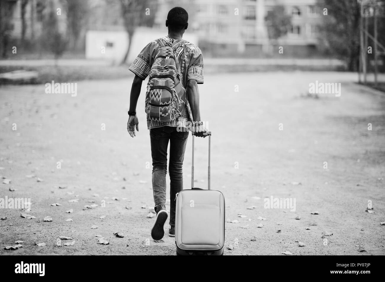 Homme africain en Afrique chemise traditionnelle sur parc automne avec sac  à dos et valise. Emigrant traveler Photo Stock - Alamy