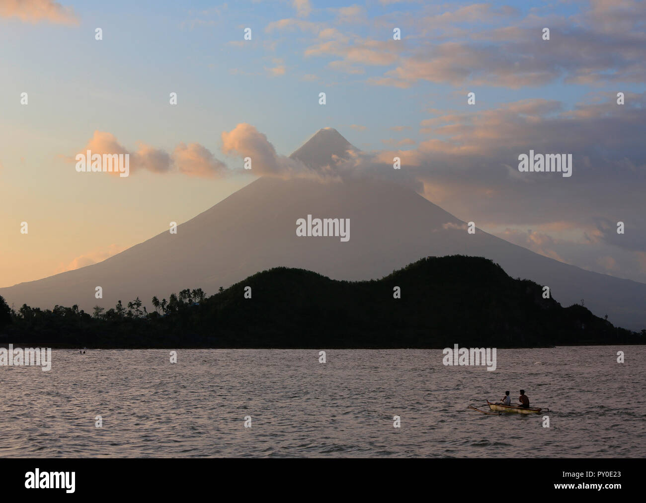 Du Volcan Mayon et gens de outrigger dans le lac au coucher du soleil, Legazpi City, la Province d'Albay, aux Philippines Banque D'Images