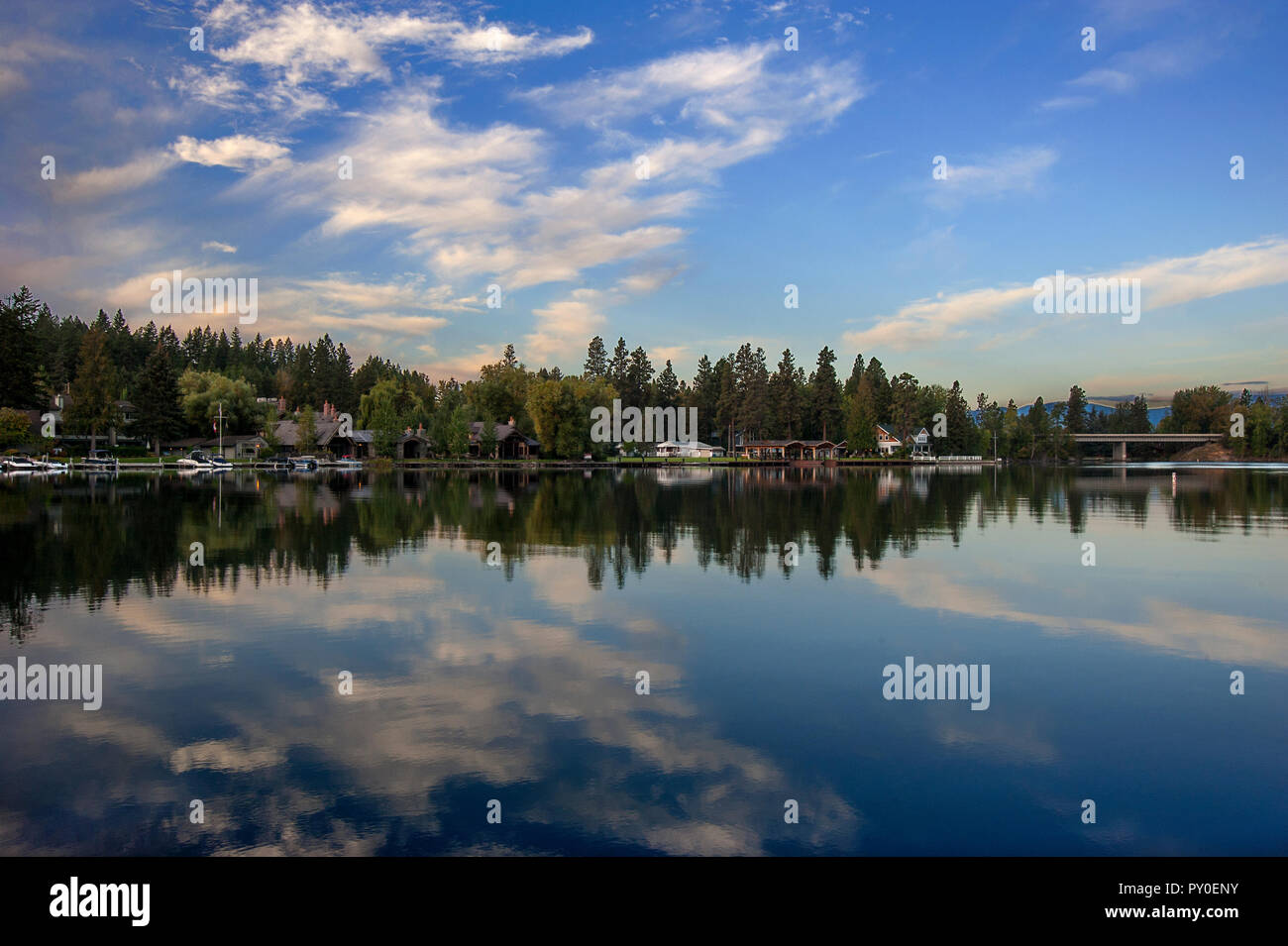 Lodges et arbres se reflétant dans l'eau claire du lac Flathead, Montana, USA Banque D'Images