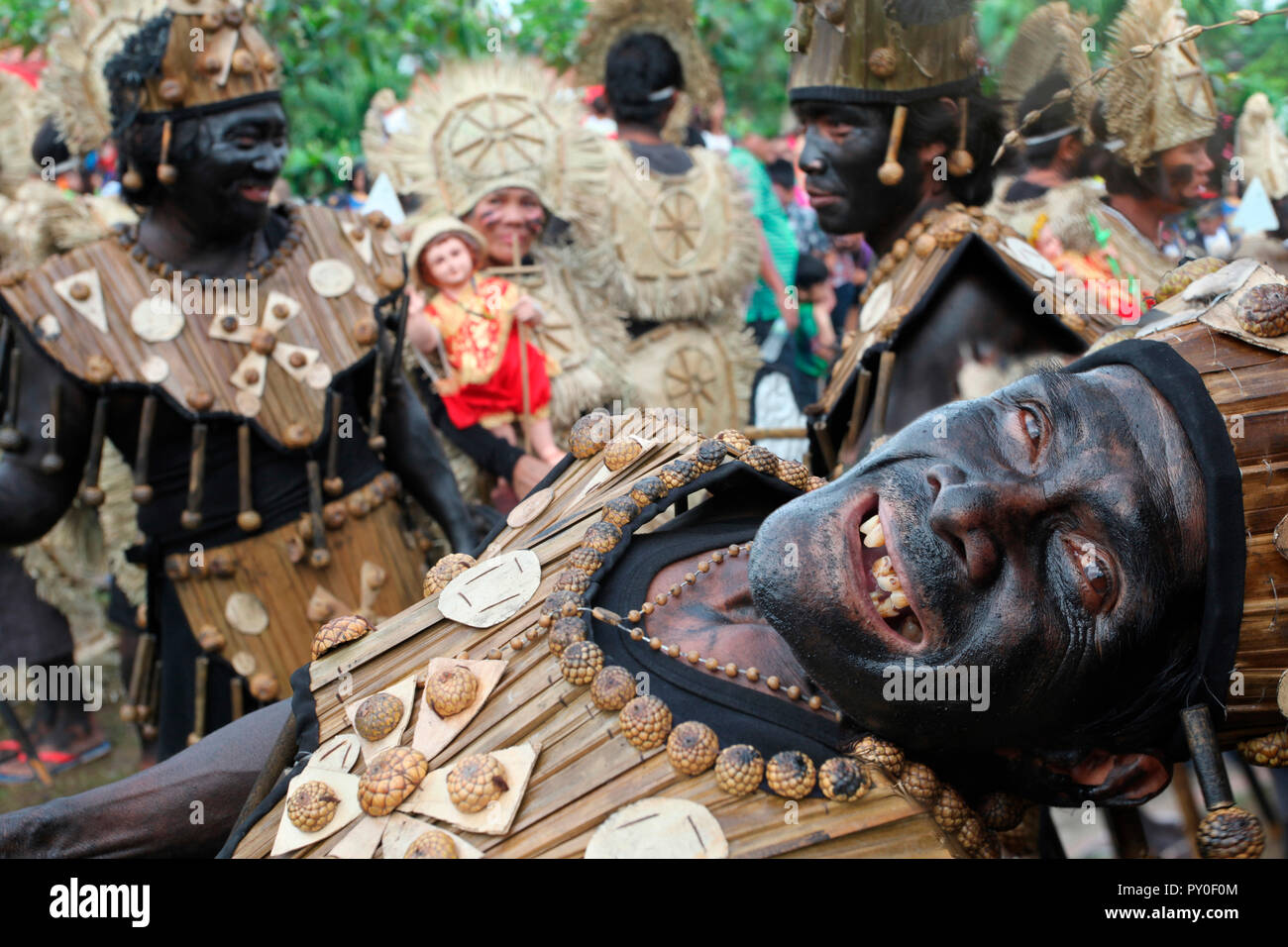 Vieil homme drôle en face de groupe de personnes, portant des costumes tribaux Ati à Atihan festival, Kalibo, Aklan, Philippines, l'île de Panay Banque D'Images