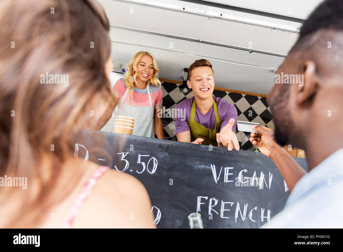 Les clients de donner carte de crédit au vendeur de camion alimentaire Banque D'Images