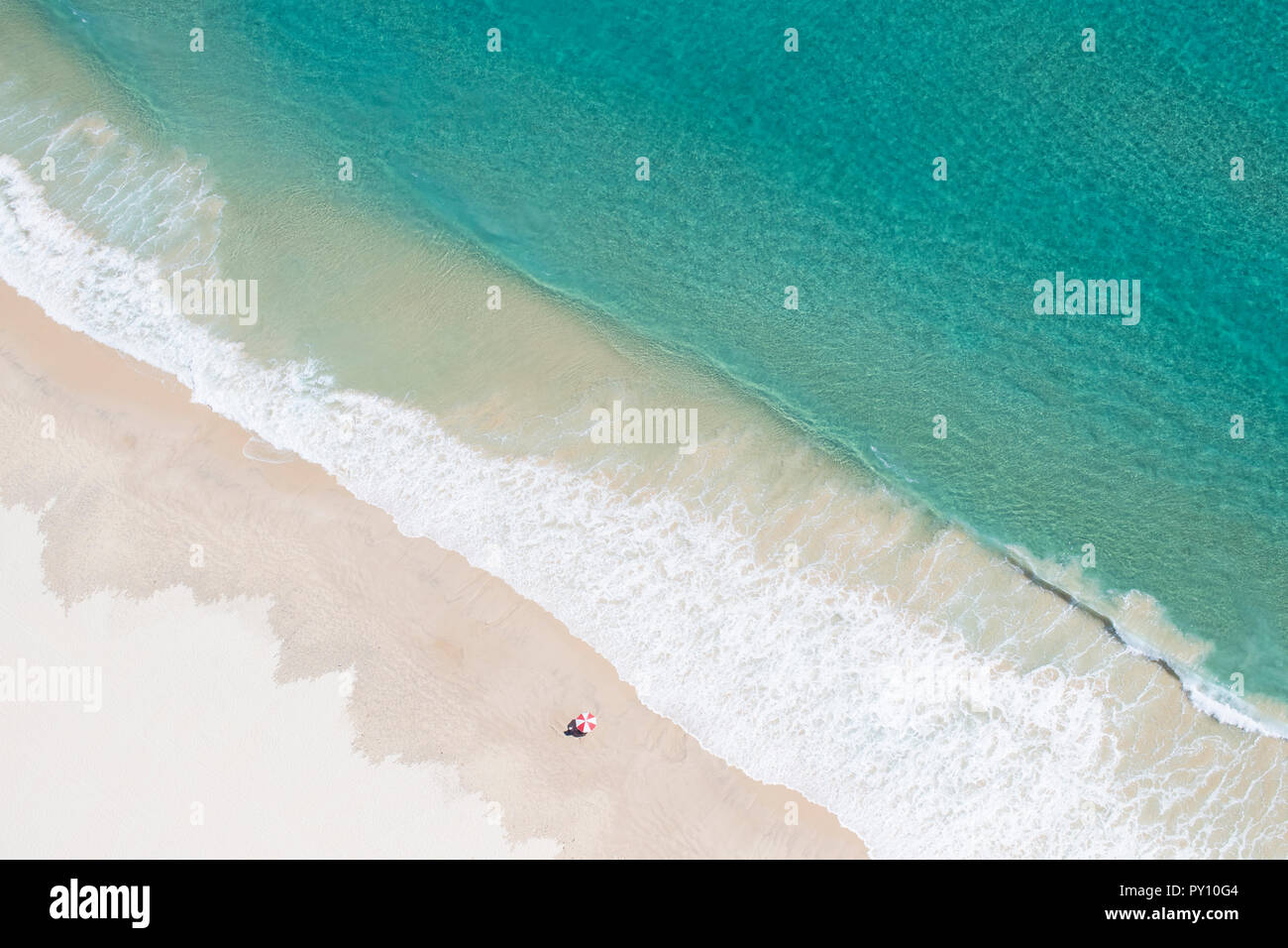 Vue aérienne d'un homme debout sur la plage par un parasol, Gold Coast, Queensland, Australie Banque D'Images