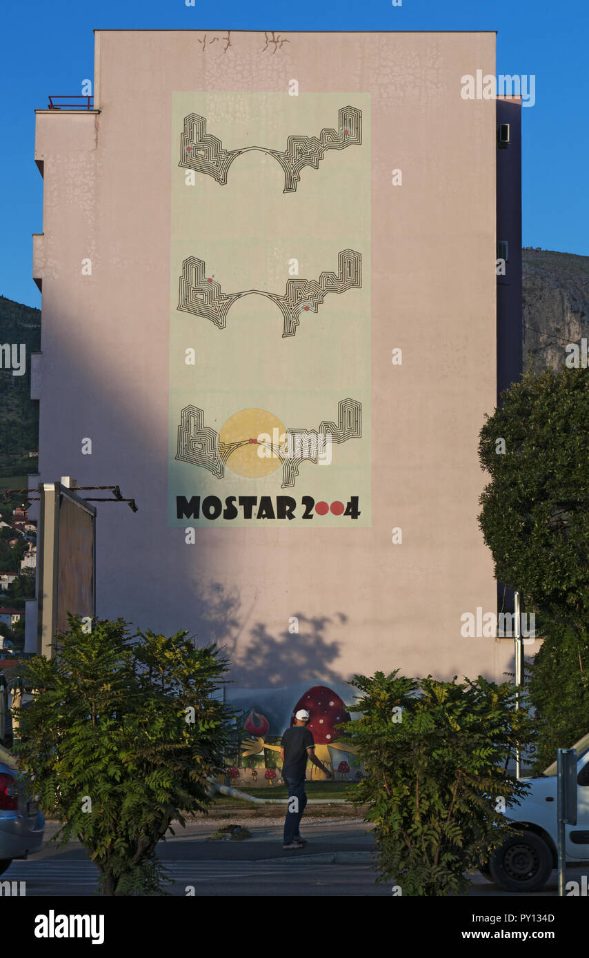 Mostar : gigantesque affiche représentant l'union des deux cultures musulmanes et catholiques sur le Stari Most (Vieux Pont) sur un palais rose Banque D'Images