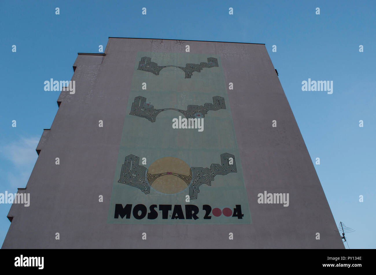 Mostar : gigantesque affiche représentant l'union des deux cultures musulmanes et catholiques sur le Stari Most (Vieux Pont) sur un palais rose Banque D'Images
