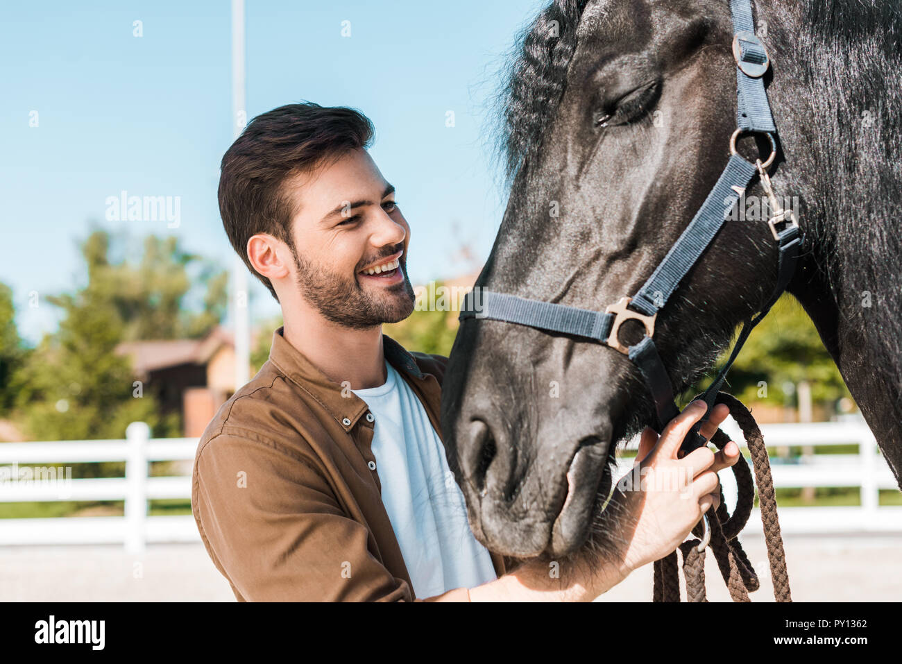 Smiling handsome cowboy cheval fixation dos-nu à horse club Banque D'Images