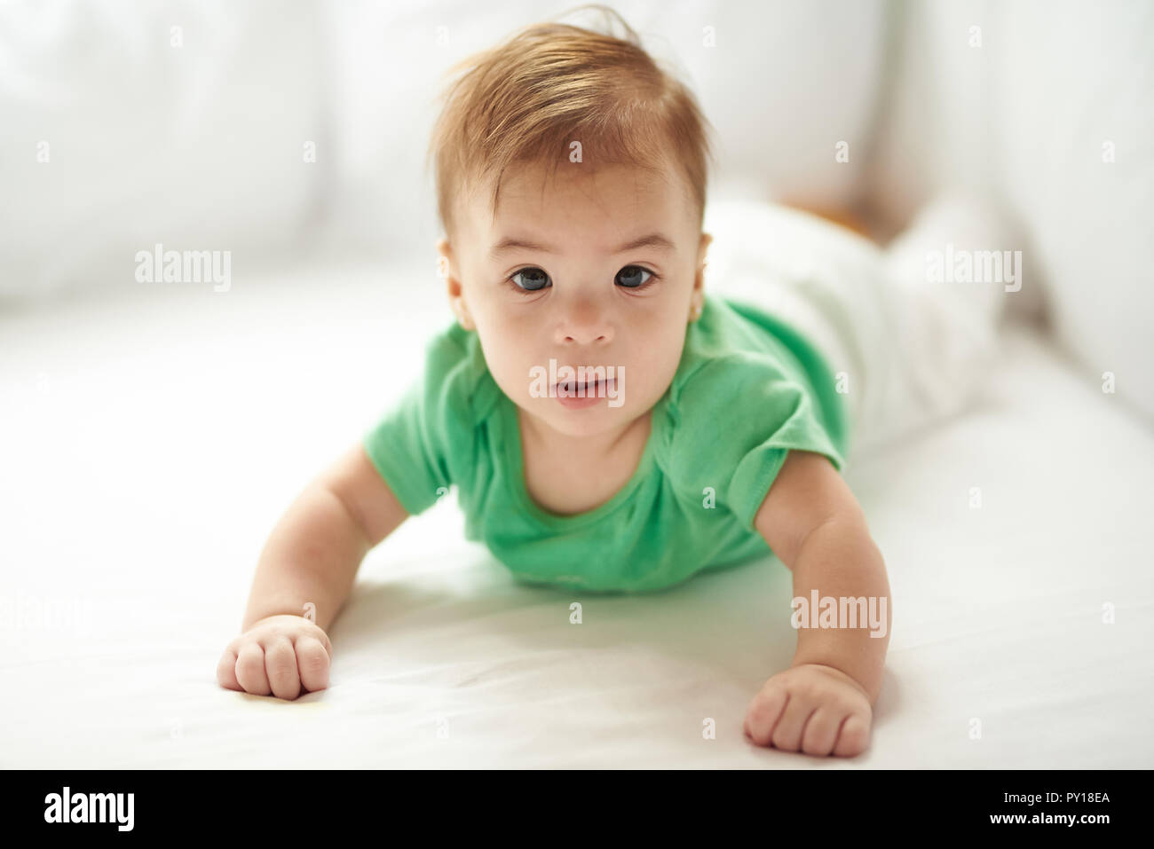 Happy baby girl jeter sur fond de lit blanc Banque D'Images