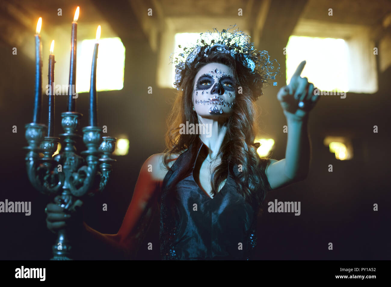 Jeune femme avec compenser pour la célébration de l'Halloween tenue un  chandelier avec des bougies allumées Photo Stock - Alamy