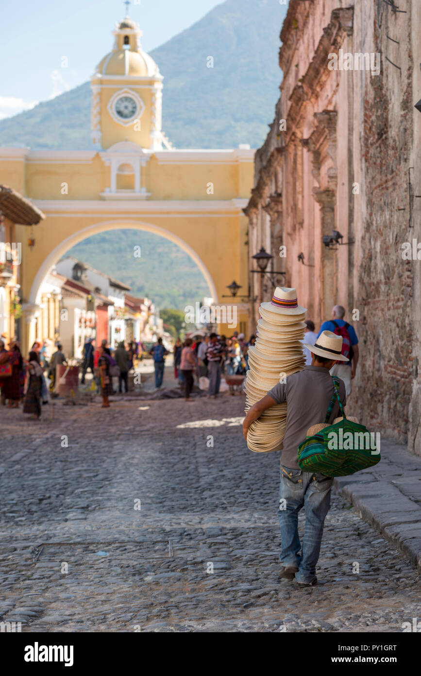 ANTIGUA, GUATEMALA - 24 février 2018 : Un homme chapeaux vente promenades au célèbre passage de Santa Catalina dans la ville touristique d'Antigua, Guate Banque D'Images