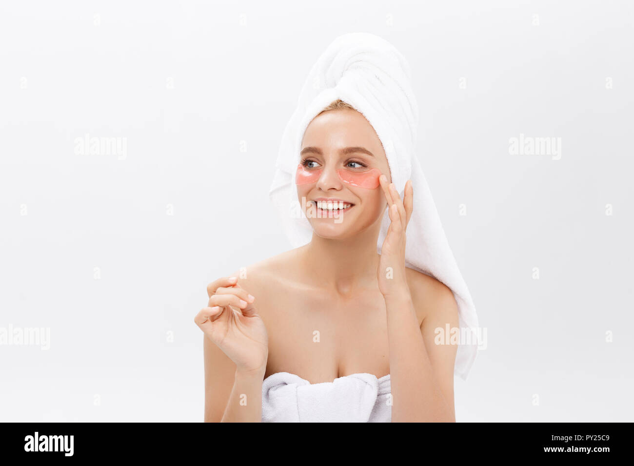 Gros plan d'une jeune femme avec des correctifs sous les yeux de rides et cernes. Isolé sur fond blanc Banque D'Images