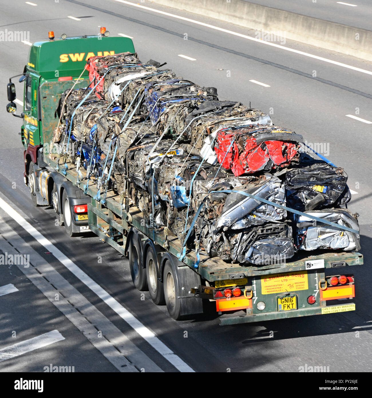 Camion Poids Lourds camion & semi-remorque plat articulé en voiture sur autoroute la lourde charge de ferraille cube écrasé pour recyclage voitures England UK Banque D'Images