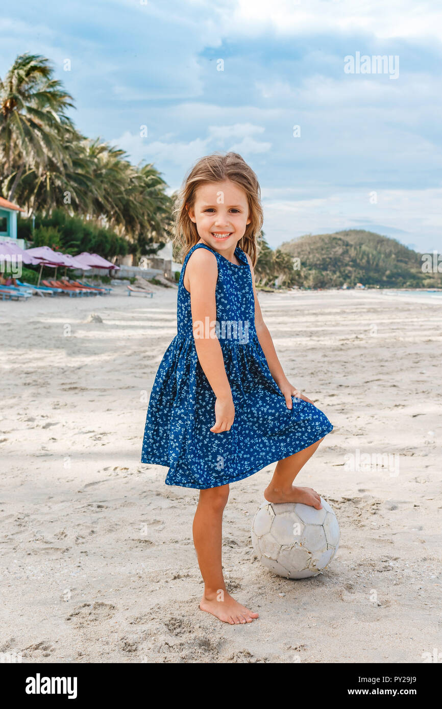 Belle petite fille avec un ballon sur la plage. Banque D'Images