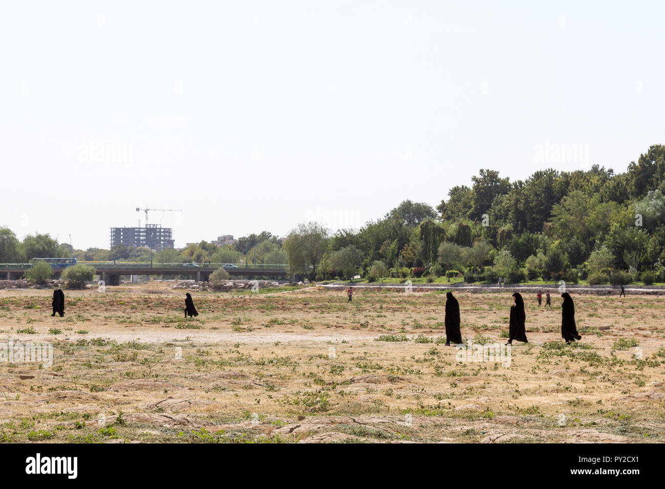ISFAHAN, IRAN - le 20 août 2016 : Les femmes portant le hijab islamique l'ion noir marche à sec de la rivière Zayandeh, particulièrement lors d'un été chaud Photo Banque D'Images