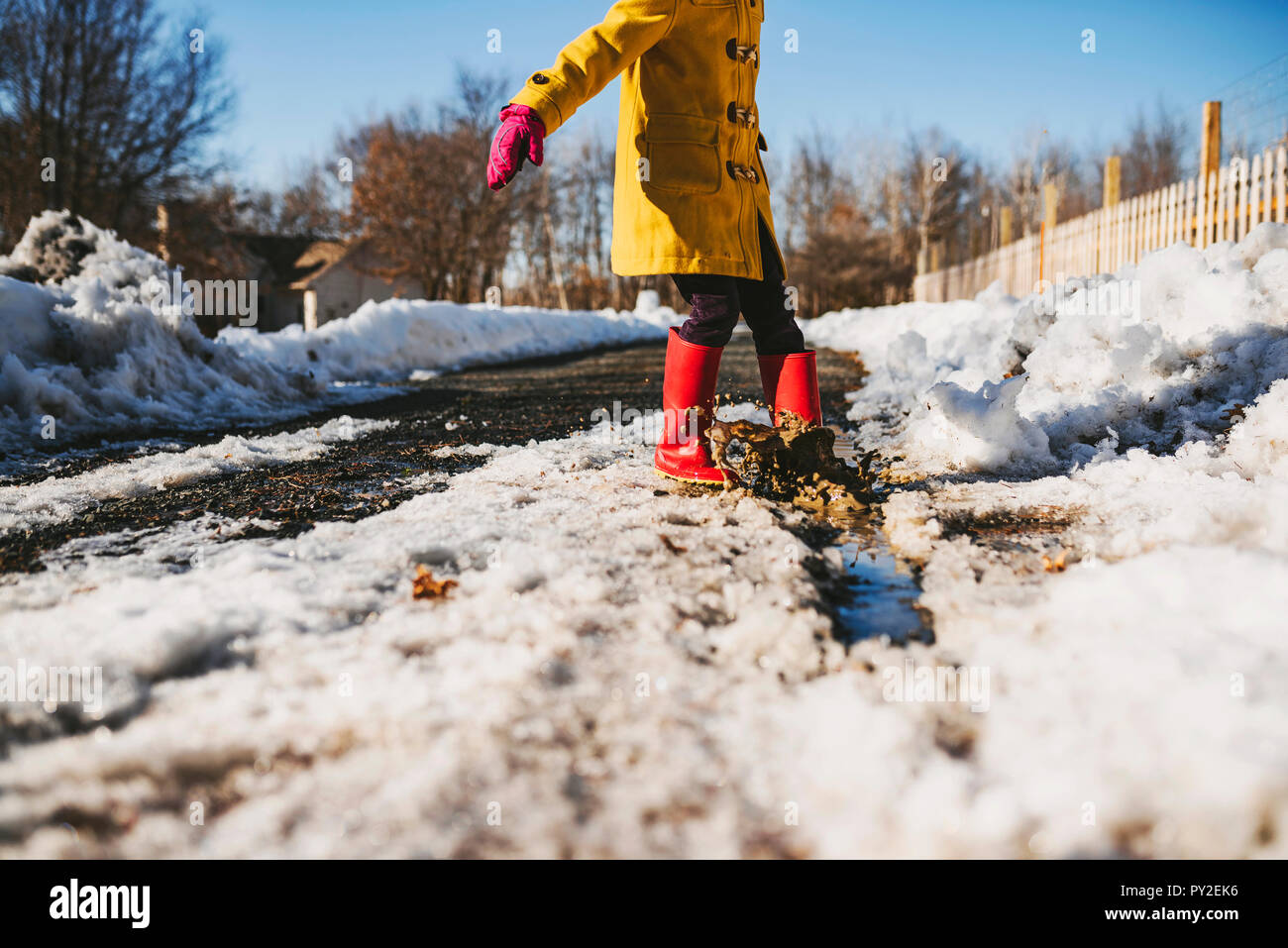 Fille debout dans une flaque de neige fondue, United States Banque D'Images