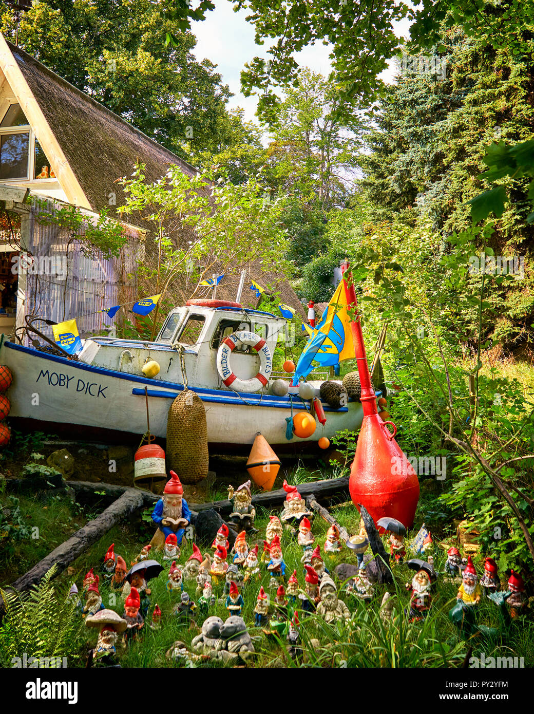 Quelques nains de jardin décoratif, en face d'un vieux bateau, décorer un jardin. Banque D'Images