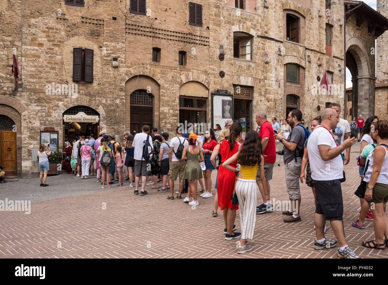 Une très longue file d'attente pour les glaces à l'extérieur de Gelateria Dondoli dans une colline de San Gimignano, Toscane, Italie Banque D'Images