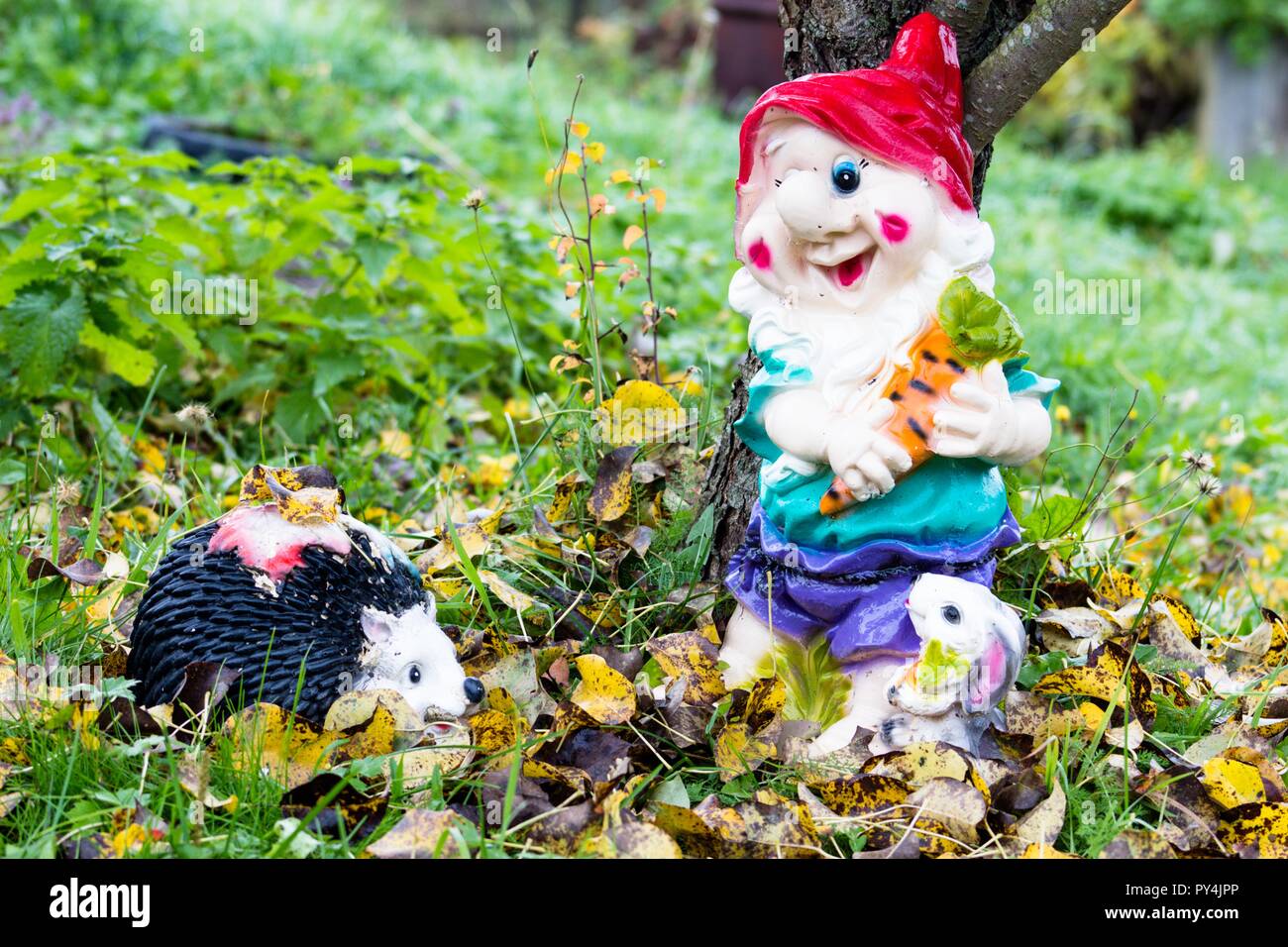 Belle et colorée avec un peu de jardin hedgehog sont debout sous un arbre. Le jaunissement des feuilles de l'arbre. L'automne est une très belle époque Banque D'Images