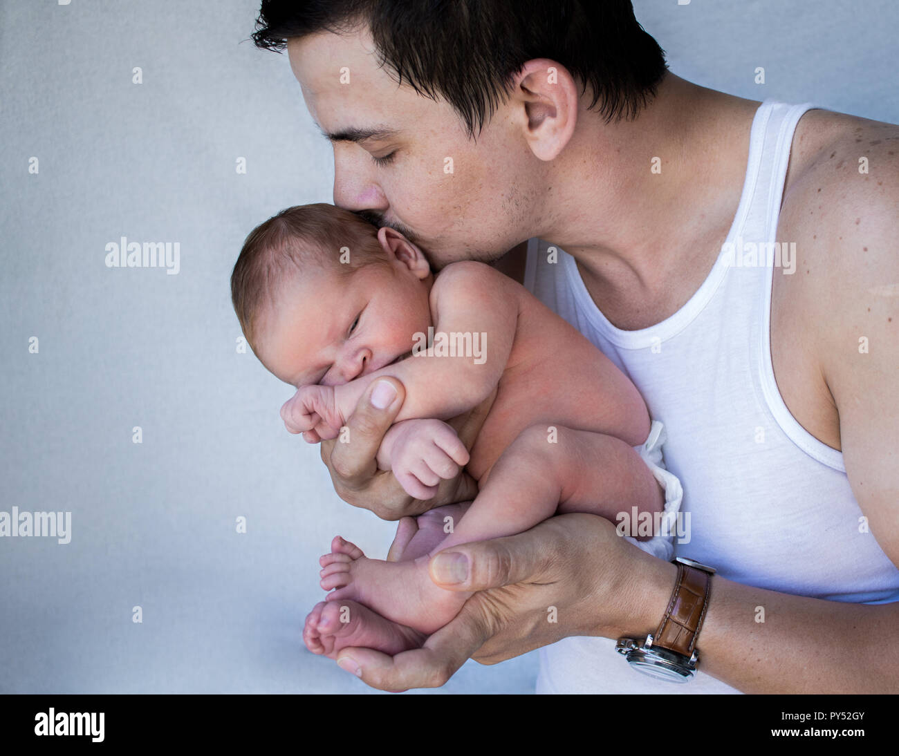Père holding new born baby fermer les baisers de sa tête. Banque D'Images