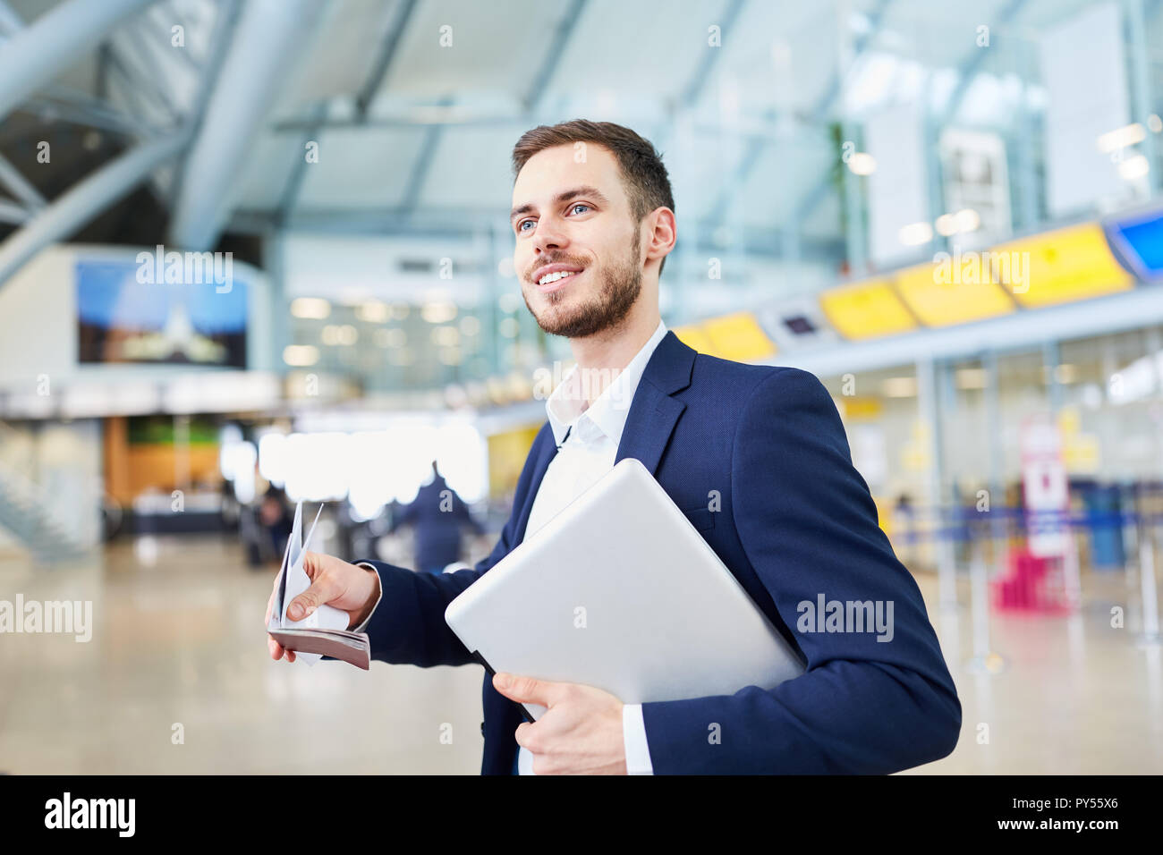 Jeune homme d'affaires en voyage d'affaires à l'aéroport le terminal avec un ordinateur portable Banque D'Images