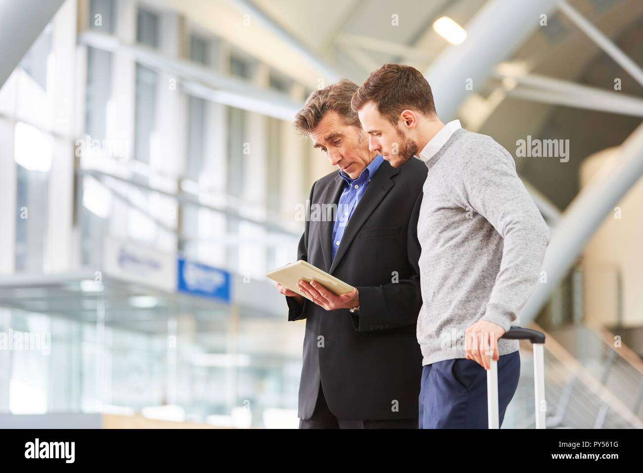 Deux business people using tablet computer tout en planifiant un voyage d'affaires à airport terminal Banque D'Images
