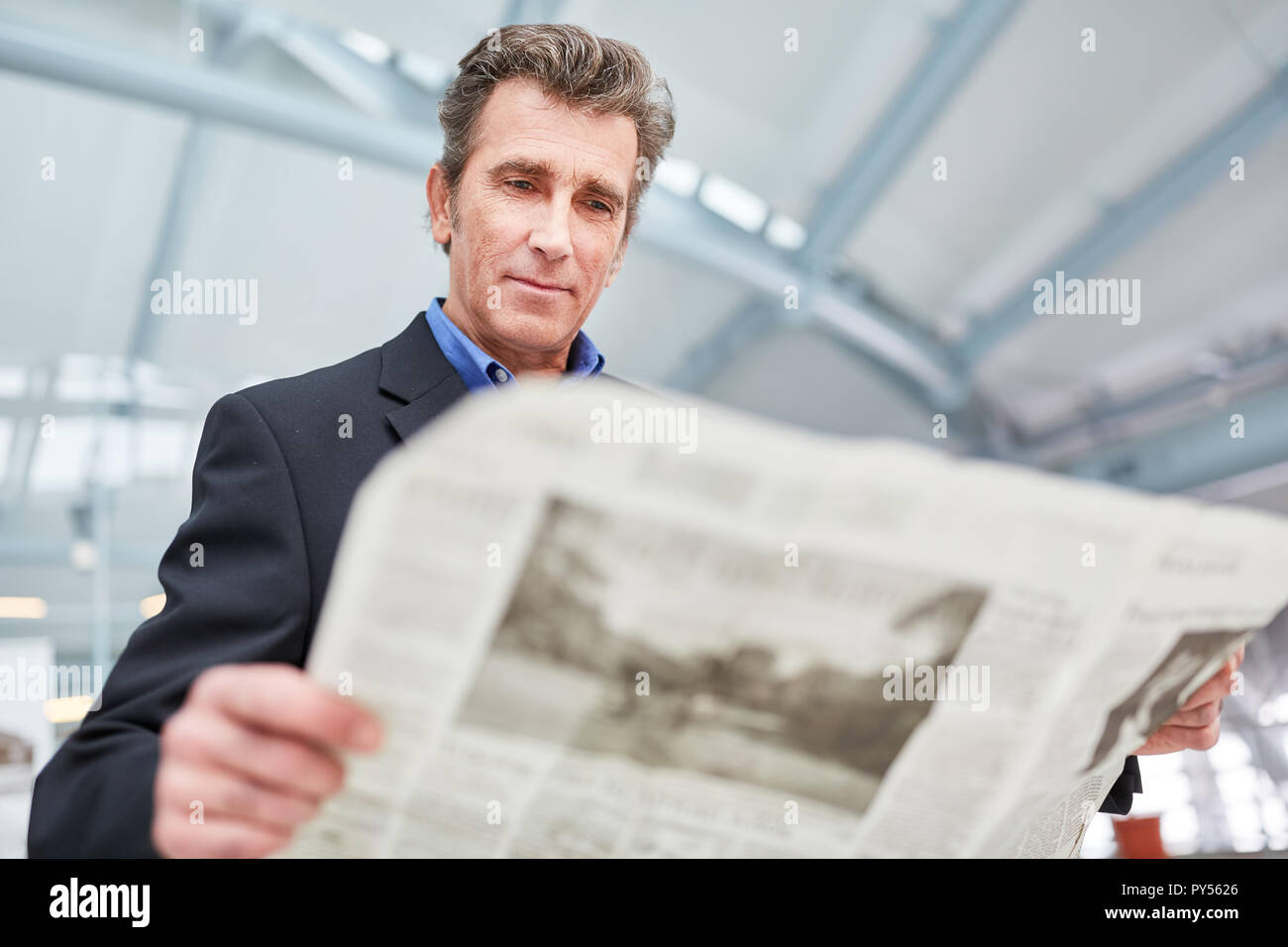 Homme d'affaires est la lecture d'un journal quotidien avant un voyage d'affaires à l'aéroport ou à la gare Banque D'Images