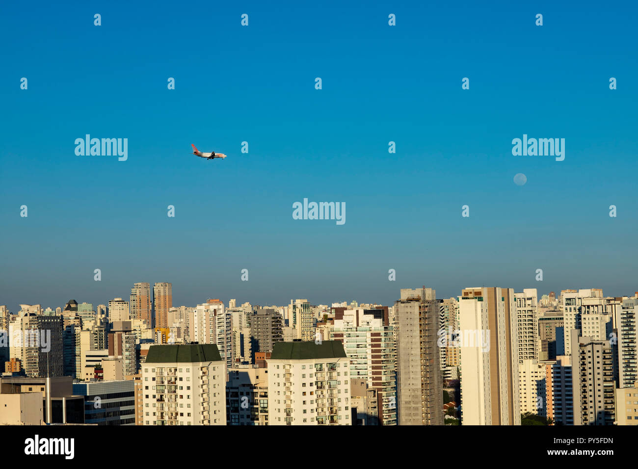 Beau paysage dans la ville, un avion et la lune sur une journée ensoleillée. São Paulo, Brésil. Banque D'Images